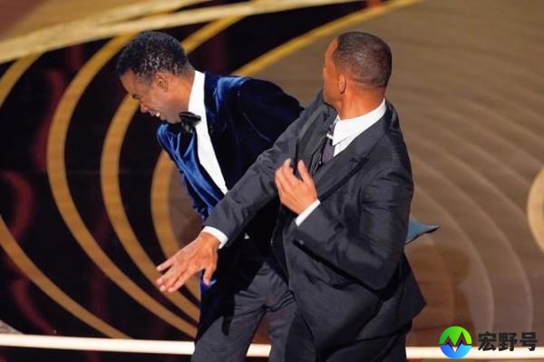 Will Smith, right, hits presenter Chris Rock on stage while presenting the award for best docu<em></em>mentary feature at the Oscars.