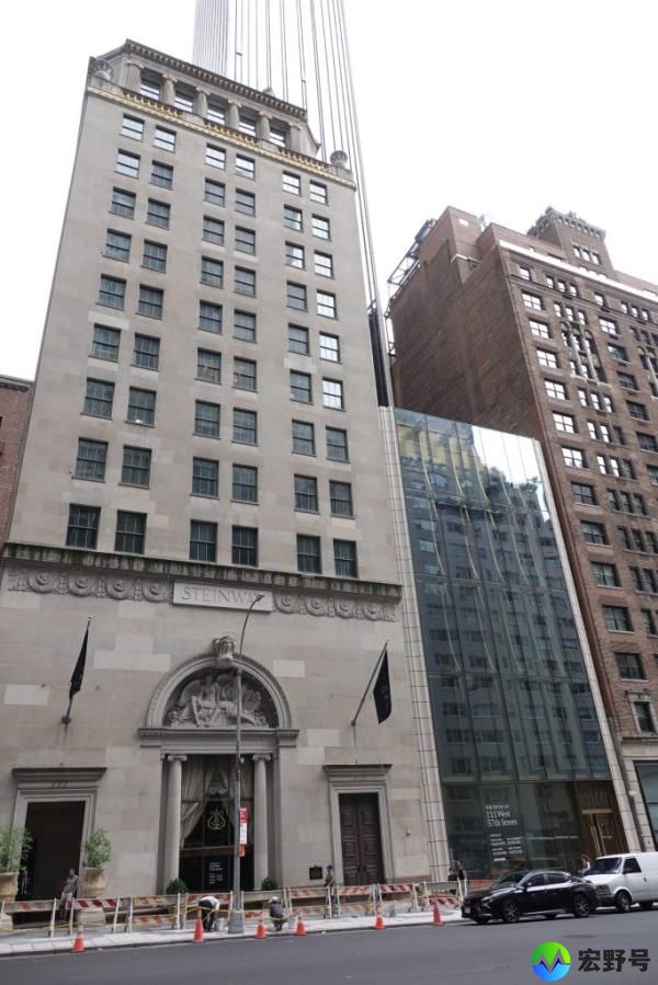 Steinway Hall and the adjacent glass retail space located at 111 W. 57 St., a tall building with many windows