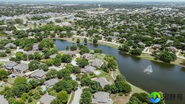 Master planned community with neighborhood pond water fountain, mature trees surrounding row of upscale two-story houses, swimming pool, in Keller, Tarrant County, Texas, suburbs Dallas, aerial. USA