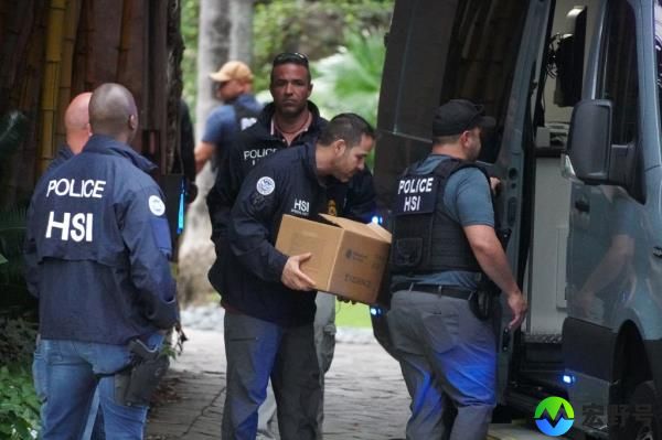 Law enforcement officers removing boxes from Diddy