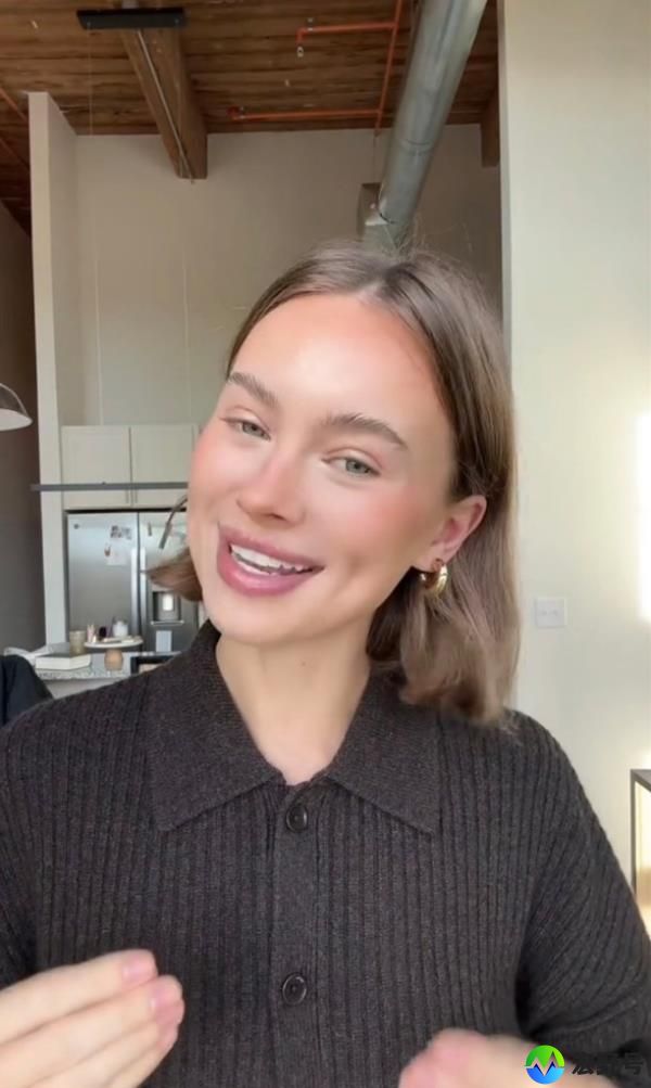 Hailey Polk smiling at the camera, embodying the beauty trend of ditching black mascara