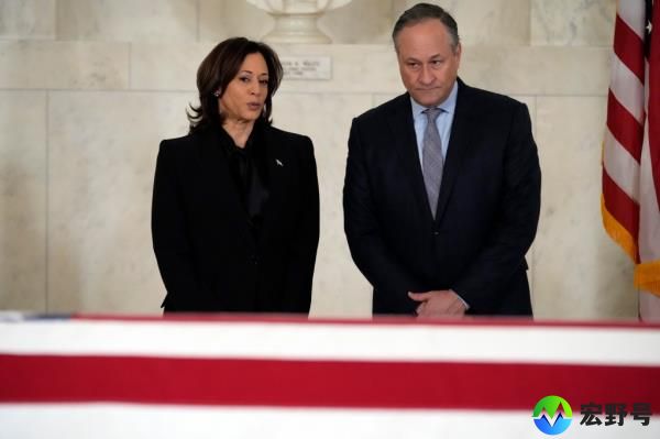 Vice President Kamala Harris and second gentleman Doug Emhoff pause in front of the casket .