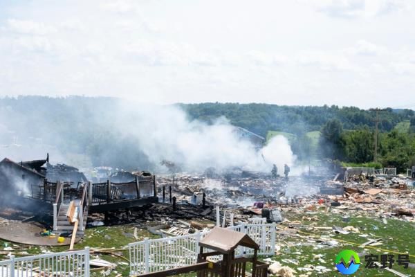 Two firefighters stand on the debris around the smoldering wreckage of the the three houses that exploded near Rustic Ridge Drive and Brookside Drive in Plum, Pa., on Aug. 12, 2023. 