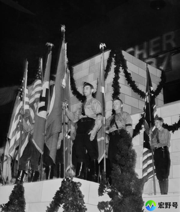 German-American Bund members stand with American and Nazi Germany flags during the rally.