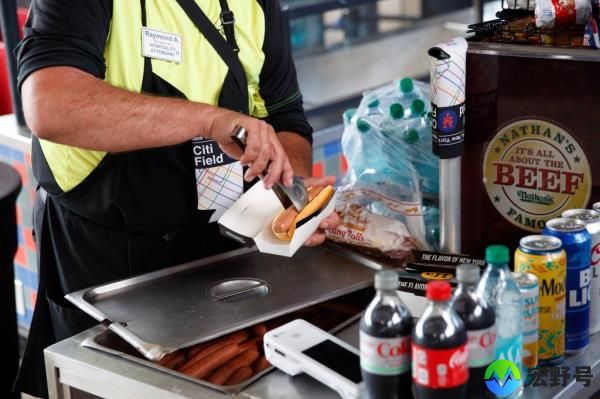 Acceta serving a hot dog.