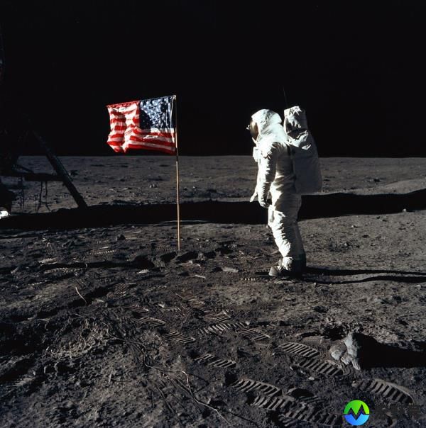 Astro<em></em>naut Buzz Aldrin posing beside the deployed US flag on the moon during the Apollo 11 mission, footprints and Lunar Module visible