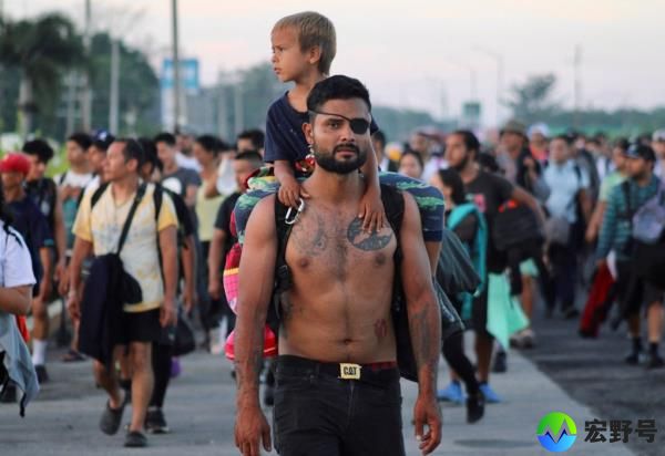 A man carries his son along a road, as migrants of different natio<em></em>nalities walk towards the U.S. in a caravan, in Ciudad Hidalgo, Chiapas state, Mexico July 21, 2024. 