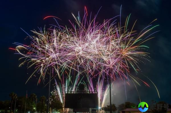 Fireworks display by the Jackso<em></em>nville Jumbo Shrimp for 2023 Independence Day celebration, fireworks seen shooting above homes and street signs in bright rainbow colors
