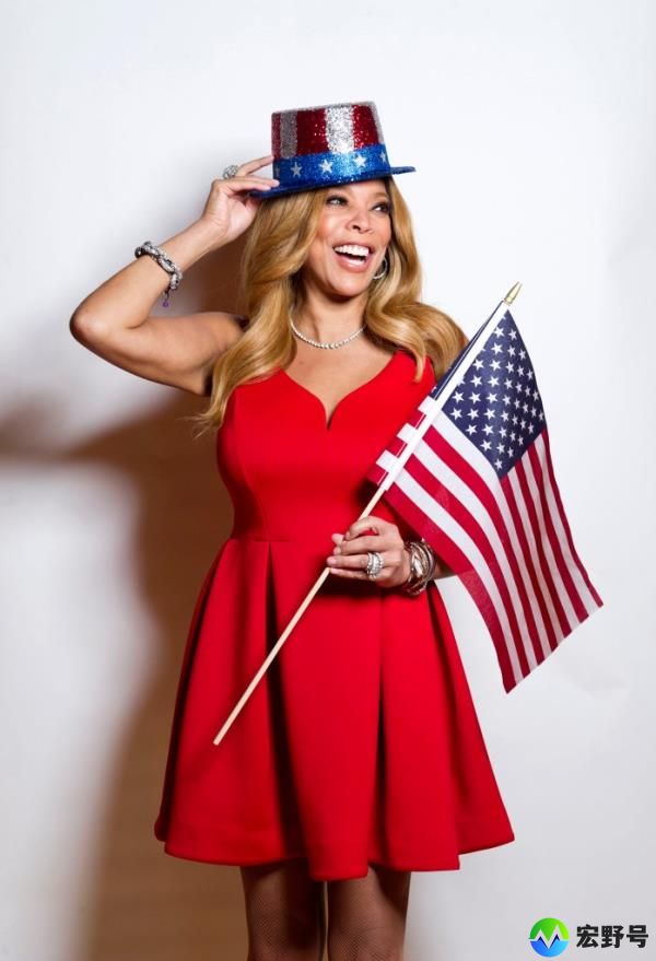 Wendy Williams in 2015, wearing a red dress and holding an American flag. 