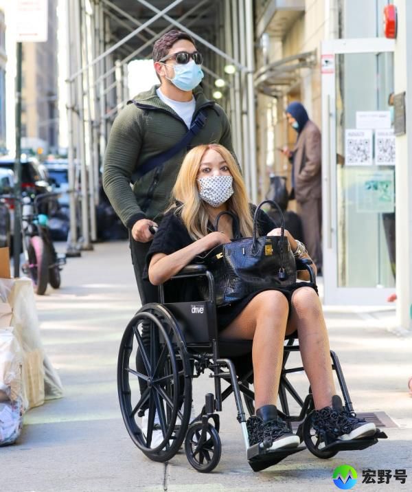 Wendy Williams pushed in wheelchair.