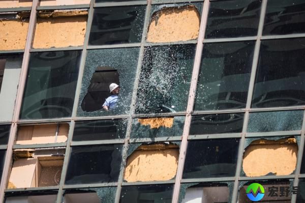 Glass falls from above as workers clean out shattered glass at the Wells Fargo building in downtown Houston following a major storm May 16.