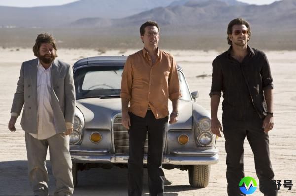Zach Galifianakis, Ed Helms, and Bradley Cooper standing outside by a car. 