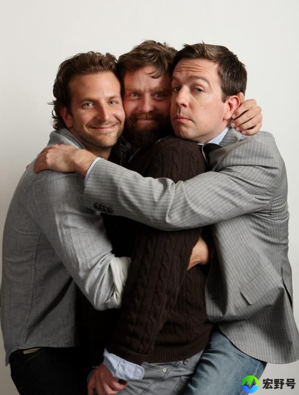 Bradley Cooper hugging Zach Galifianakis and Ed Helms. 
